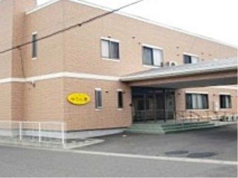 玄関前に、手すり付きの階段が設置されている施設の外観