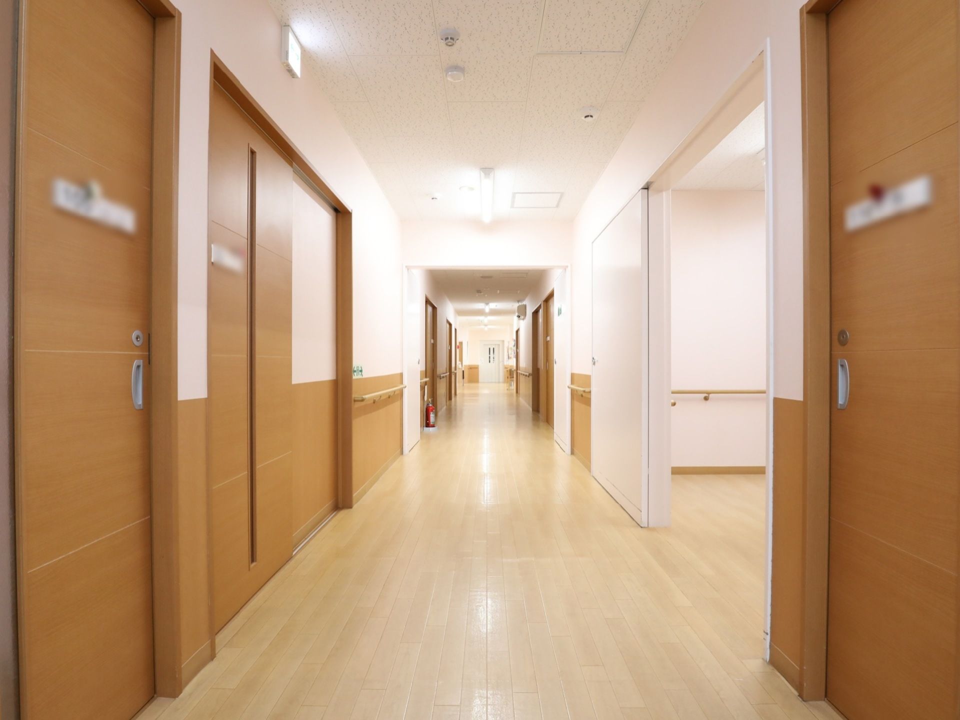 廊下はゆったりとした幅となっており、白色と茶色で統一された内装になっている。左側には、居室がたくさん並んでいる。