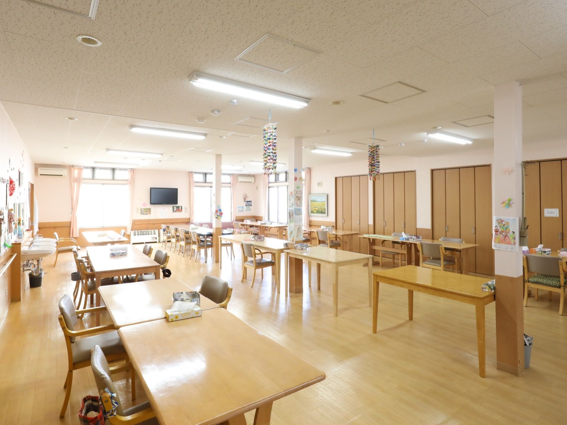 食堂は広々としており、テーブルと椅子が複数並べられている。ベージュ色の椅子もたくさん用意されている。