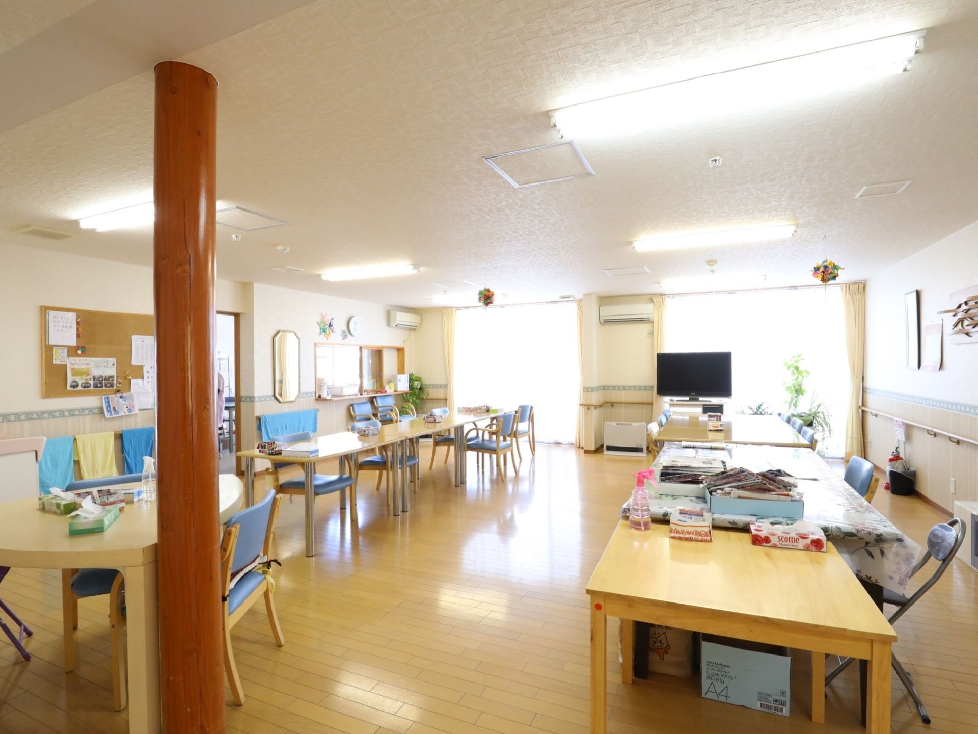 広々とした明るい食堂である。横2列にダイニングテーブルが並べられている。大型液晶テレビが完備されている。