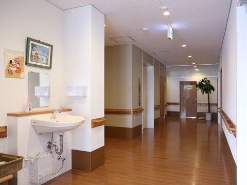 廊下の途中に設置されている、鏡付きのシンプルな洗面台