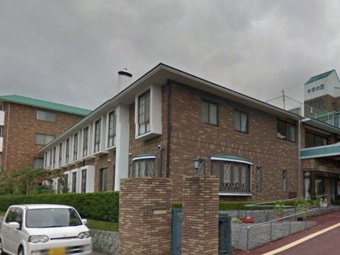 敷地入り口付近から建物を見ると、複数の建物が繋がっている様子がわかる。玄関はガラスの自動ドアで、上にはひさしがある。