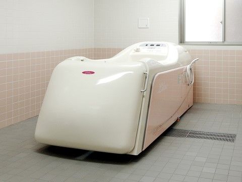 介護浴槽が設置されている、清潔感あふれるタイル張りの浴室
