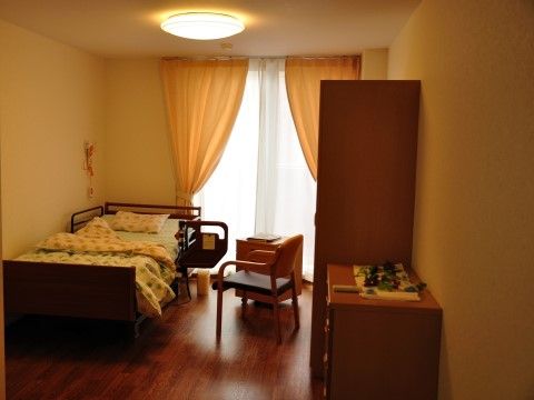 木目調のフローリングの居室は、明るくぬくもり感のある空間である。ベッドの横にはナースコールを備え、緊急時の体制もしっかりと整えている。