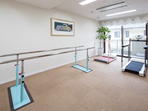 日々の体力づくりやリハビリに利用できる器具が置かれた部屋。ルームウォーカーや平行棒が設置されている。