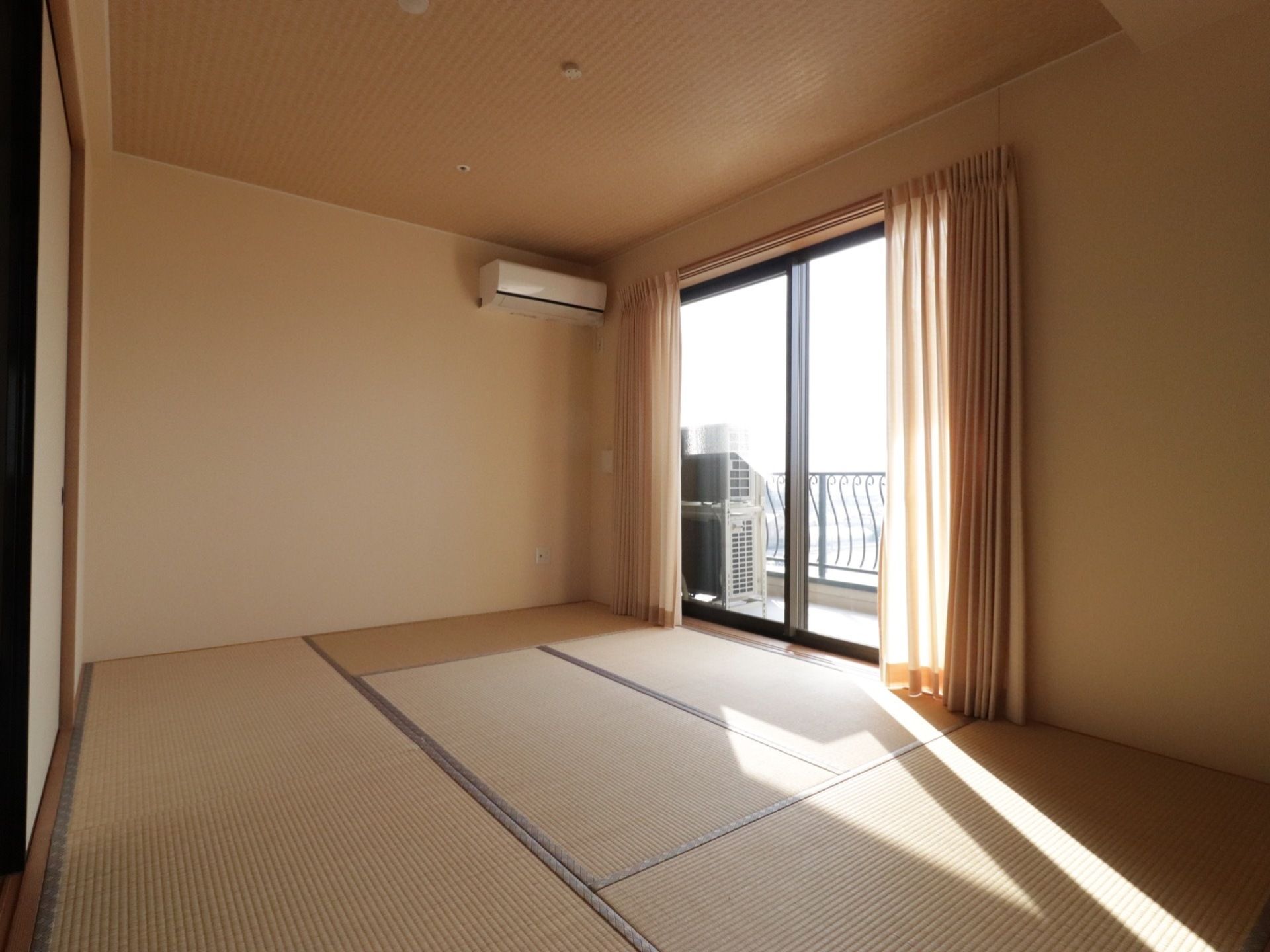 ６畳の畳の和室の部屋がある。窓が設置されていて、外の光が差し込んでいる。窓からベランダへと出られる。