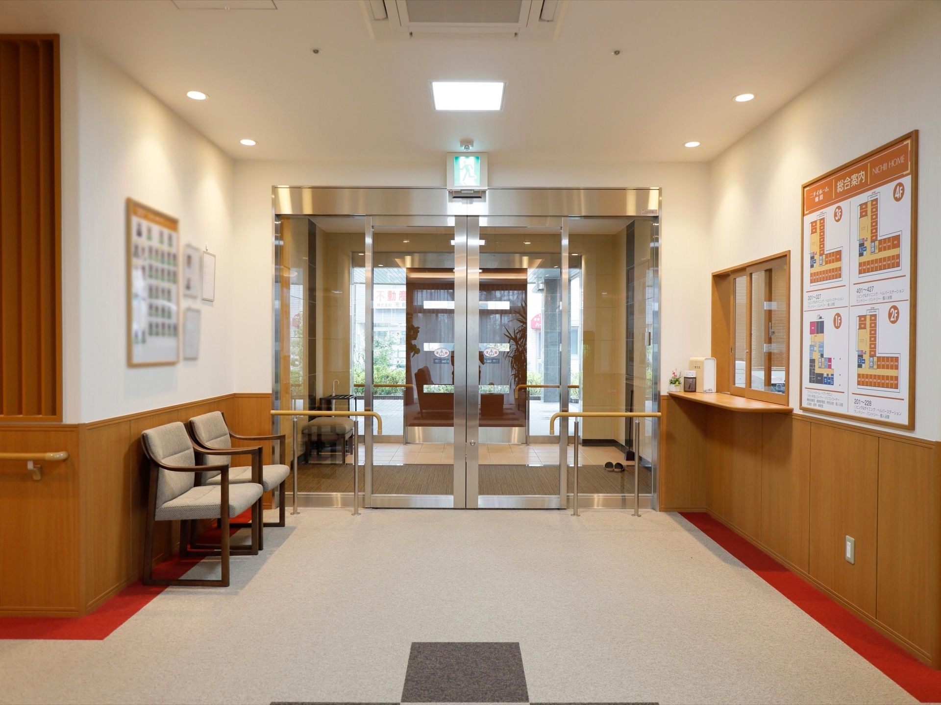 自動ドアの右横に、受付カウンターが設けられている。すぐ横の壁には、総合案内板がある。左側には、椅子が置かれている。