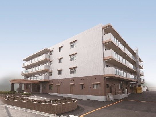 「ニチイホーム 朝霞」の外観。緑に囲まれた、清潔感のある建物。