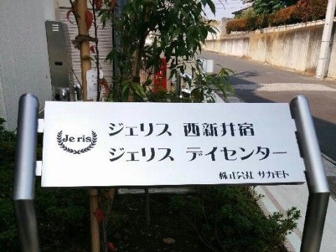 花壇に設置されている、ステンレス製の施設名が書かれた看板