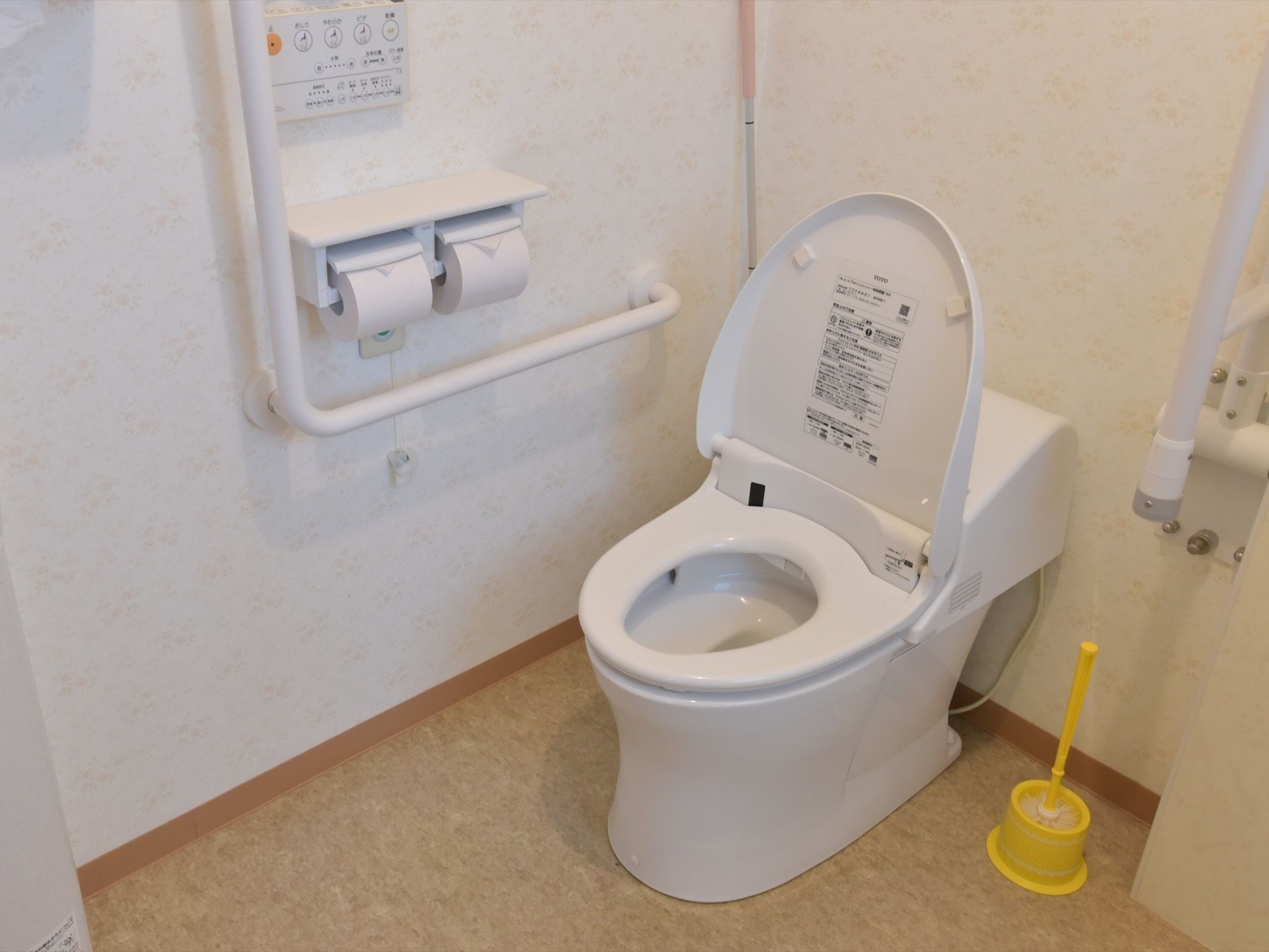 白い壁とライトブラウンの床が明るい雰囲気の広々としたトイレには、緊急の場合の通報装置が取り付けられている。