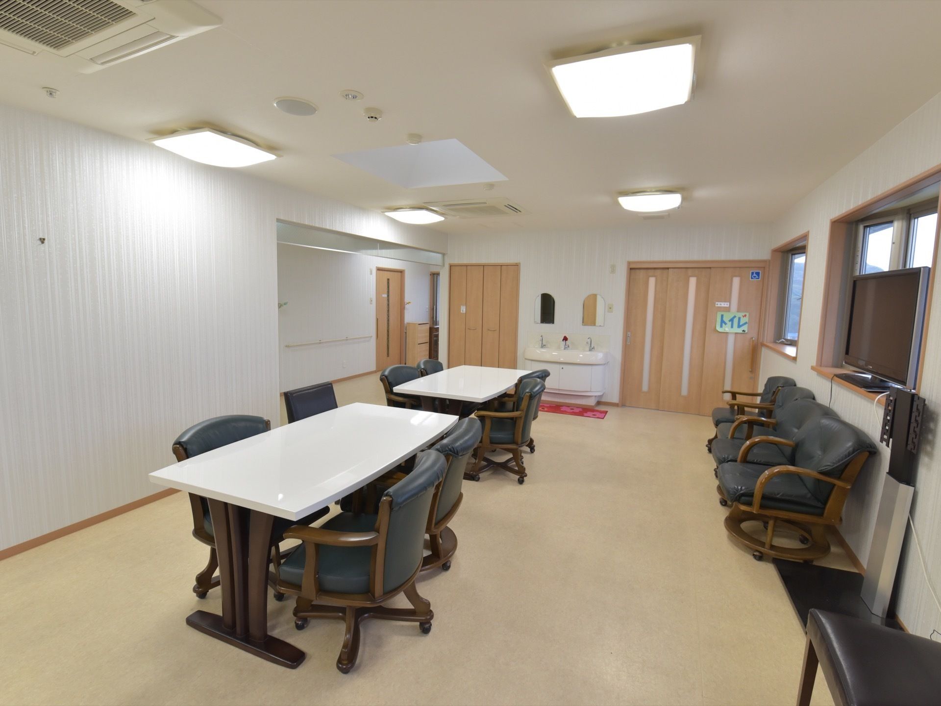 廊下からオープンになっている広々とした共有スペースにはゆったりと寛げる椅子が置かれ、トイレと洗面スペースが設けられている。