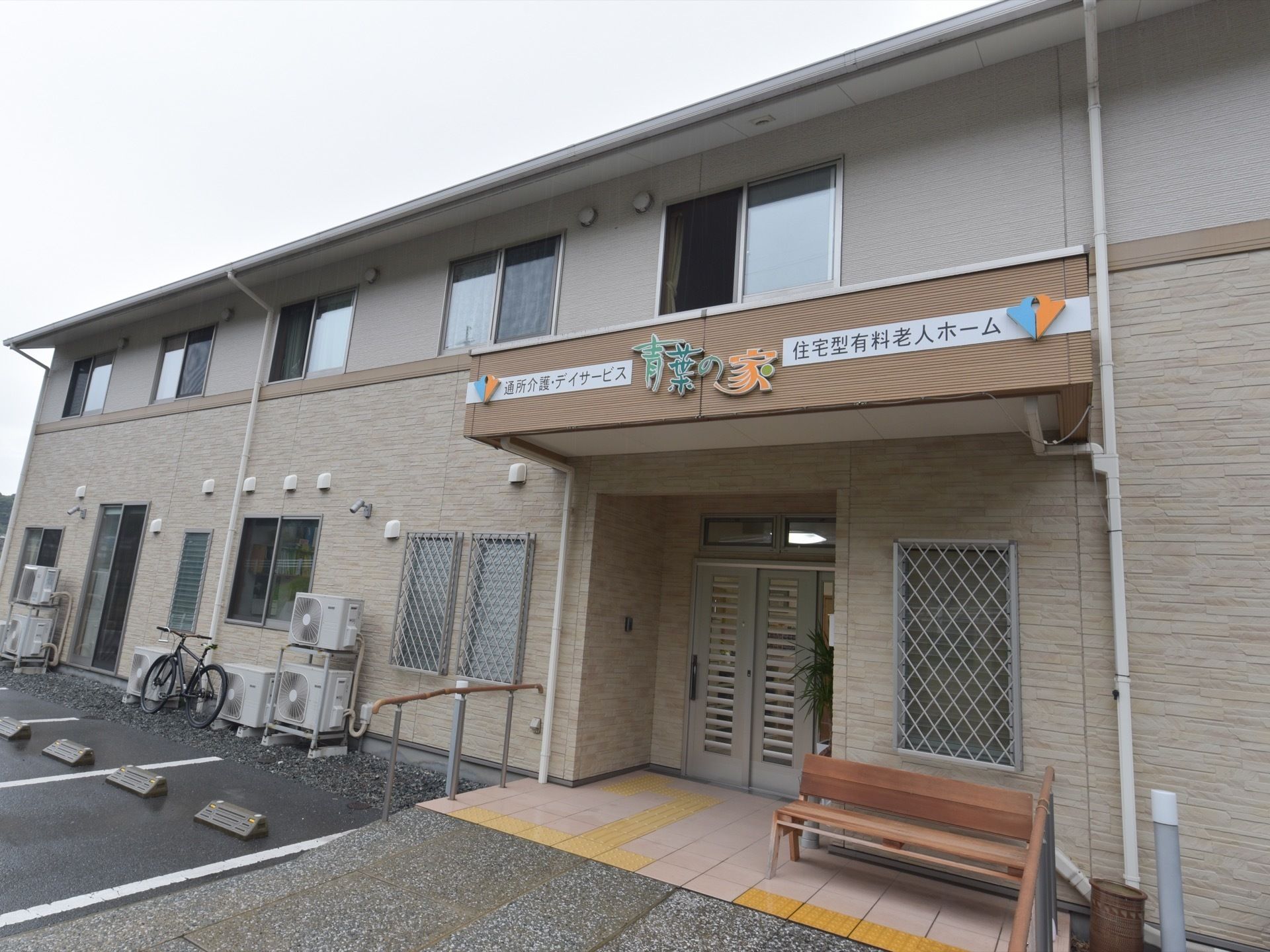 黄色い点字ブロックや木製のベンチが設置されているエントランス