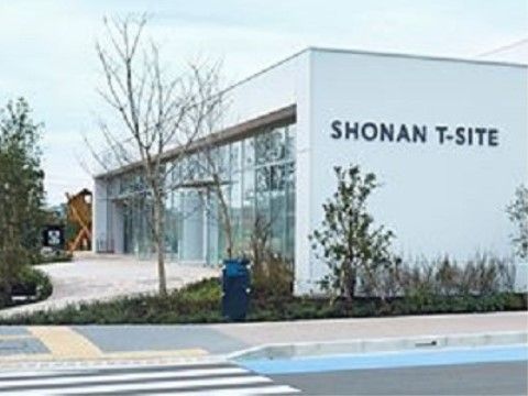 無駄を省いたすっきりとした白い建物である。建物の周囲にはかん木が植えられており、道路に面した場所に青色の郵便入れが置かれている。