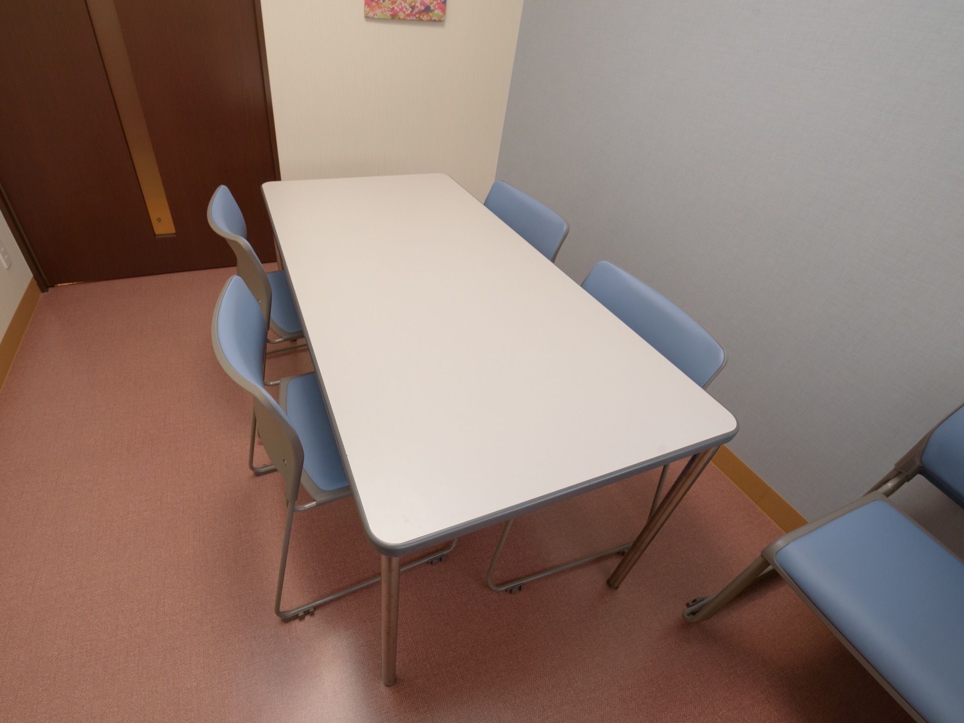 コンパクトな室内に、４人掛けのテーブルと椅子が用意されている。静かな空間で落ち着いて話が出来る環境になっている。