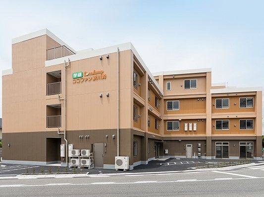たくさんの小窓がある、ベージュとからし色を基調とした大きな建物