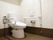 トイレの床は茶色となっている。トイレには両側に手すりが設置されている。片側がU字型でもう片側はL字型である。