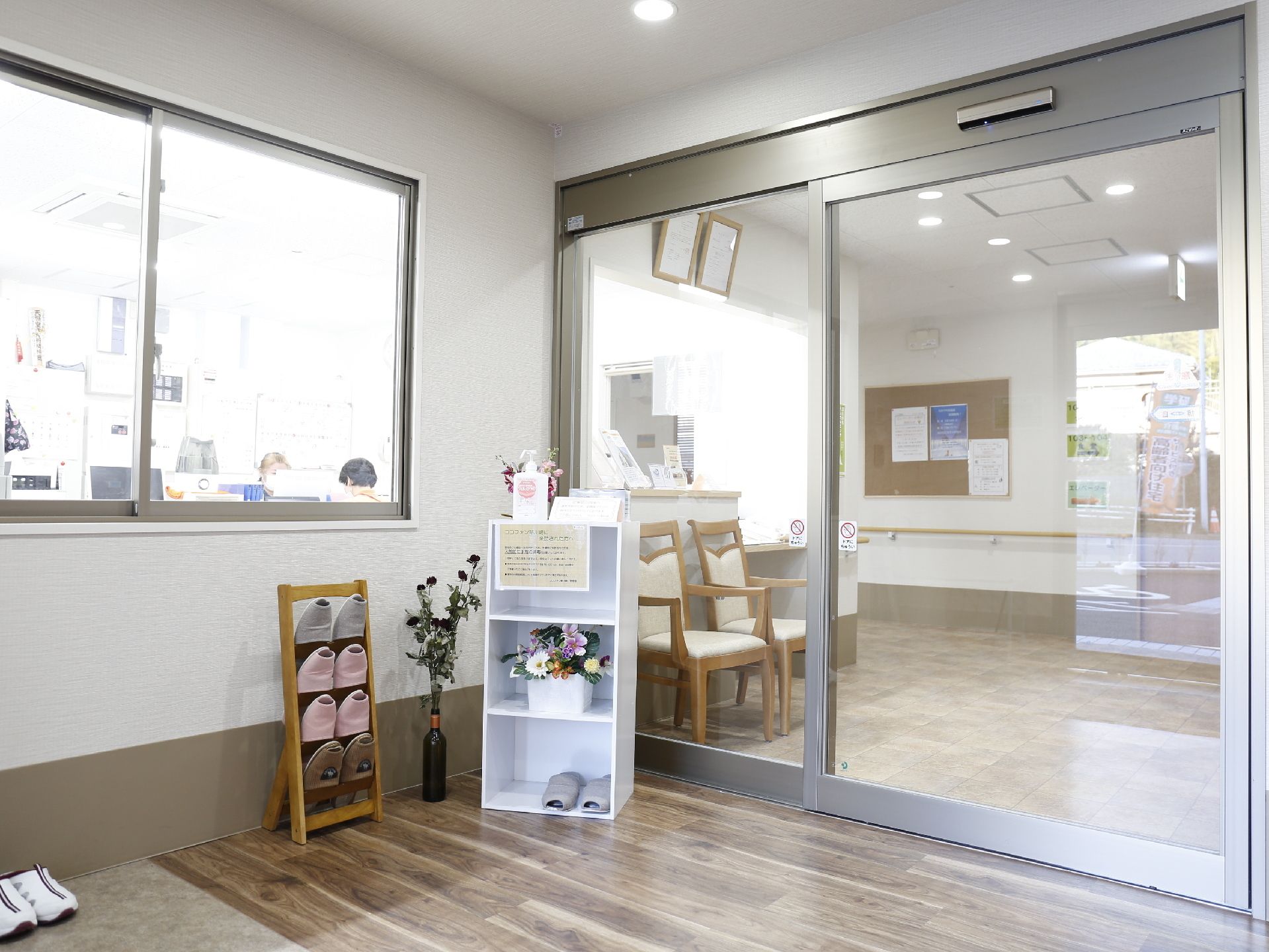 玄関には自動ドアがある。また、玄関前にはスリッパ立てとスリッパを用意している。また、花なども飾られている。
