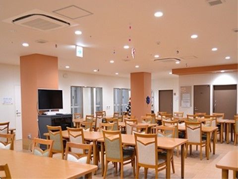 木製のダイニングテーブルセットが置かれている広い食堂