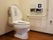 広々としたトイレ内には、ウォッシュレットの便器がある。手すりが近くに設置され、ボタンで簡単操作が可能。