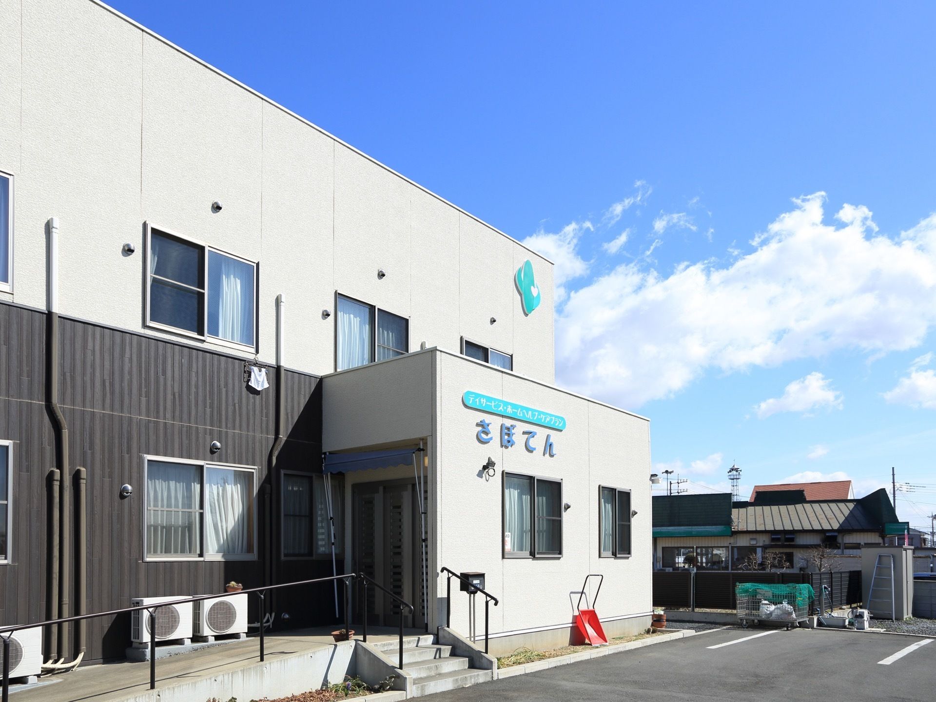 施設は、外壁がベージュ色とダークブラウンになっている２階建ての建物である。施設名が玄関近くの外壁に表示されておりわかりやすい。