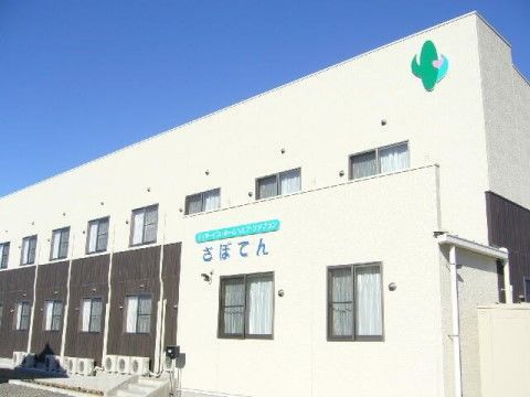 外壁にサボテンの絵が描かれている、２階建てのグループホーム