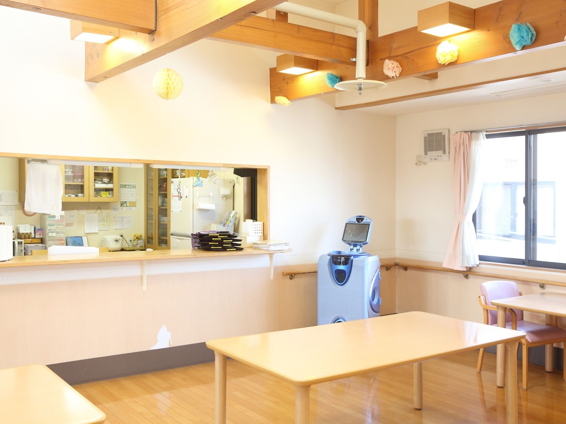 木の床に木製のテーブルがいくつかある。天井は木製の梁がそのまま見える形である。調理室とはカウンターでつながっている。