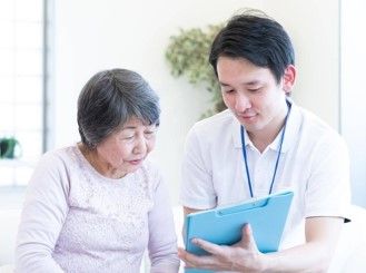 男性が女性に対してバインダーで何かを見せている
