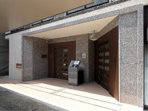 石造りの外壁と木製のドアがスタイリッシュなエントランス