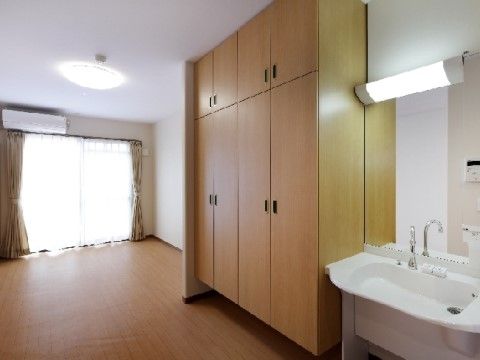 大きな収納と洗面台が備え付けられている、洋室タイプの居室