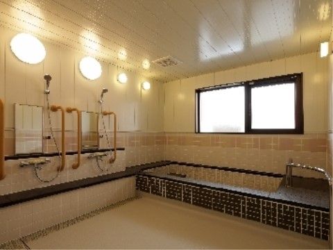 大きめの浴槽を備えた浴室。入居者様の転倒防止のために手すりも設置されており、安全にご入浴を楽しんでいただける。