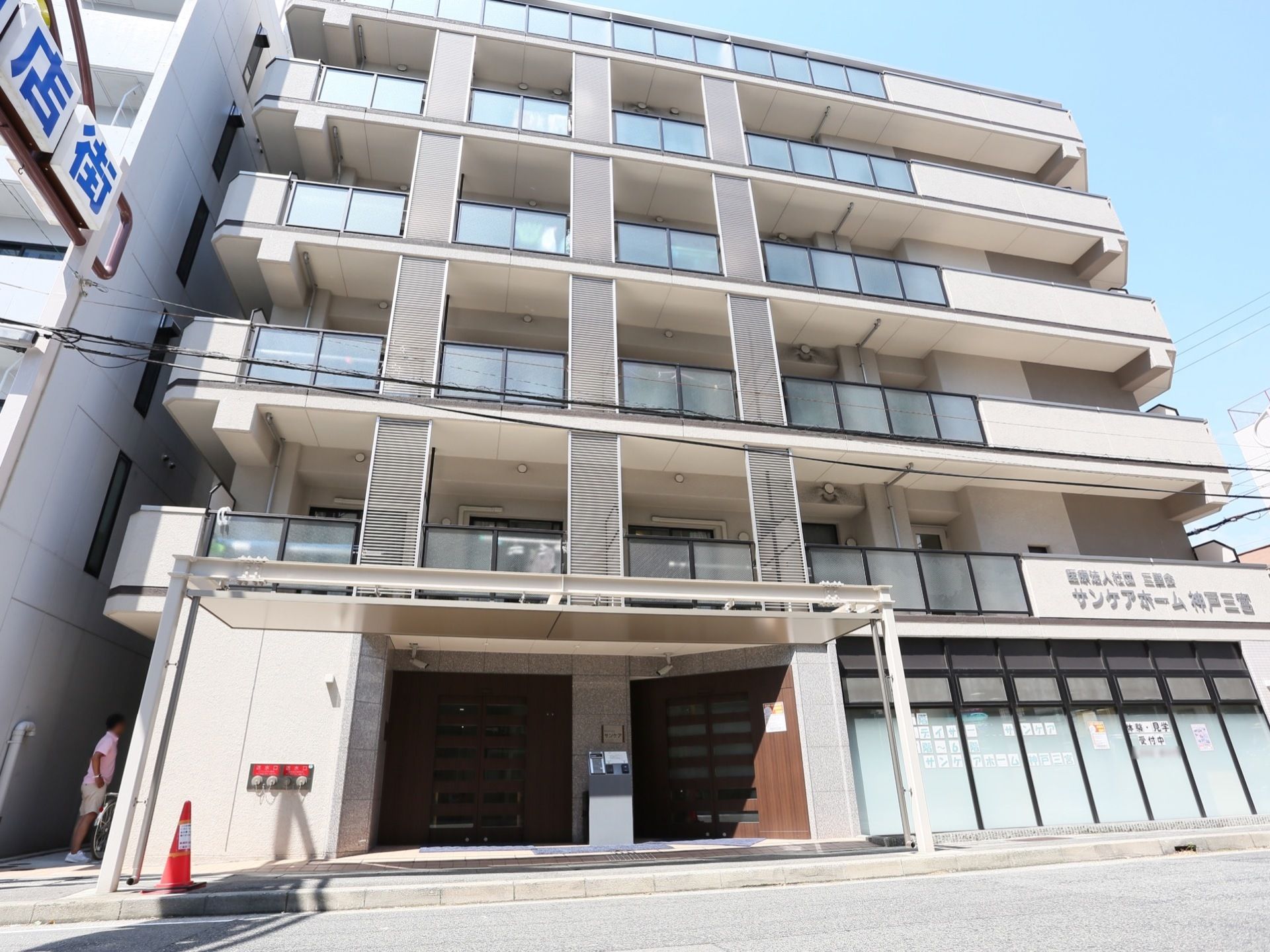 施設は６階建てのマンションのような外観である。外からは各部屋のベランダがみえる。一階に入口があり、入口近くには消火用散水栓がある。