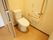 トイレのドアはスライド式である。便座の周りには長い手すりが設置されている。緊急時の呼び出しボタンもついている。