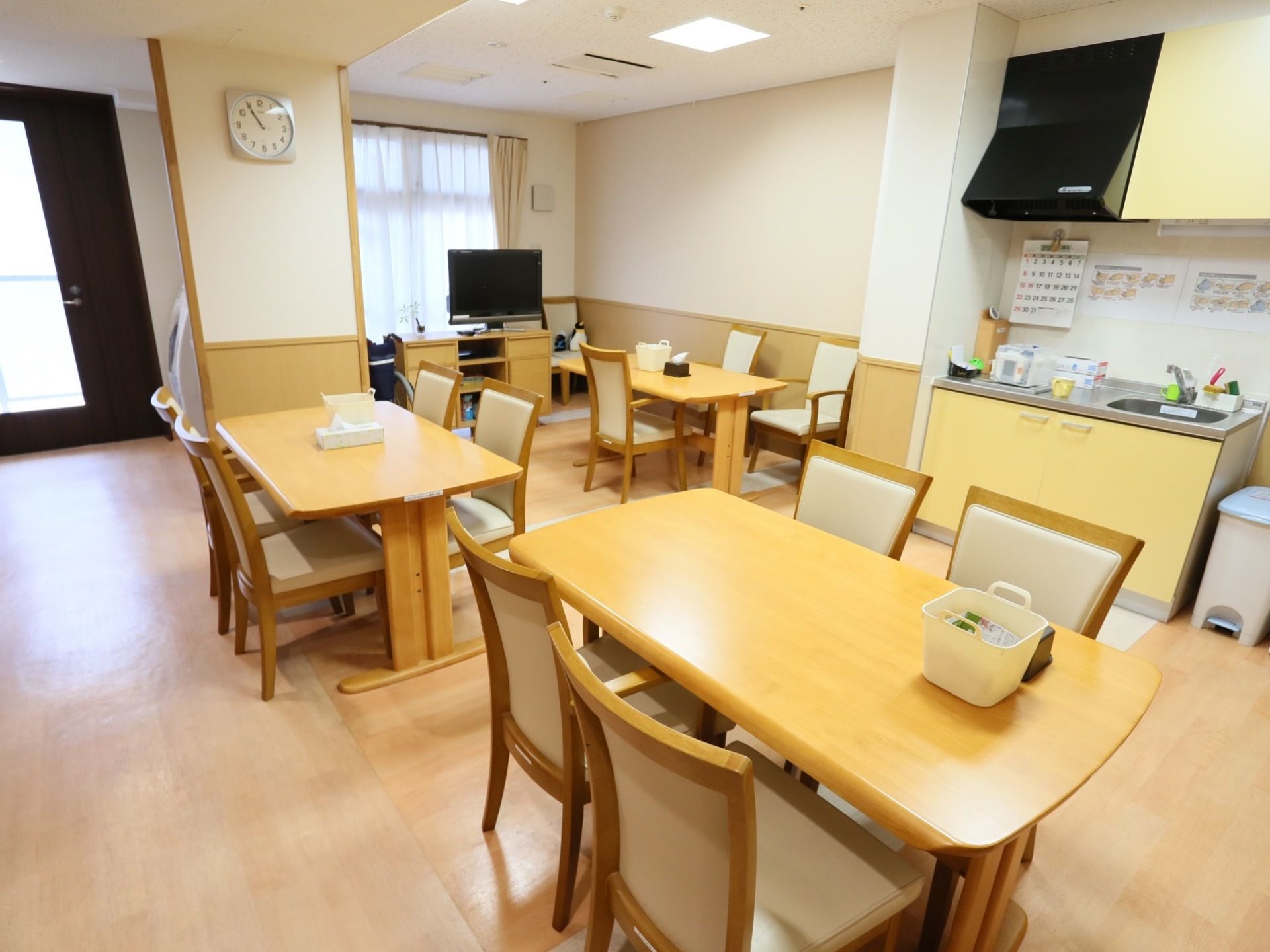 テーブルが数多く置かれ、食事をすることができる。流し台が設置され、調理小物を収納できる戸棚もついている。奥にはテレビもある。
