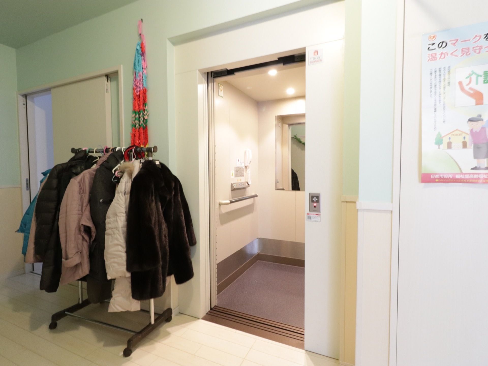 エレベーターが１基完備されている。中には鏡と手すりが設置されている。ドアの左側に千羽鶴が飾られている。