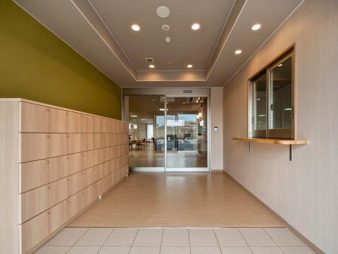 木製の大きな扉付きの靴箱が設置されている、エントランス