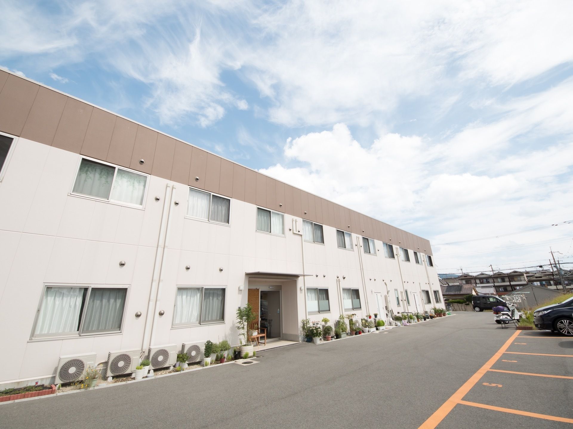 施設周辺には、鉢植えや花壇に植えられた植物が多く配置されている。緑が鮮やかな開放的な空間づくりである。