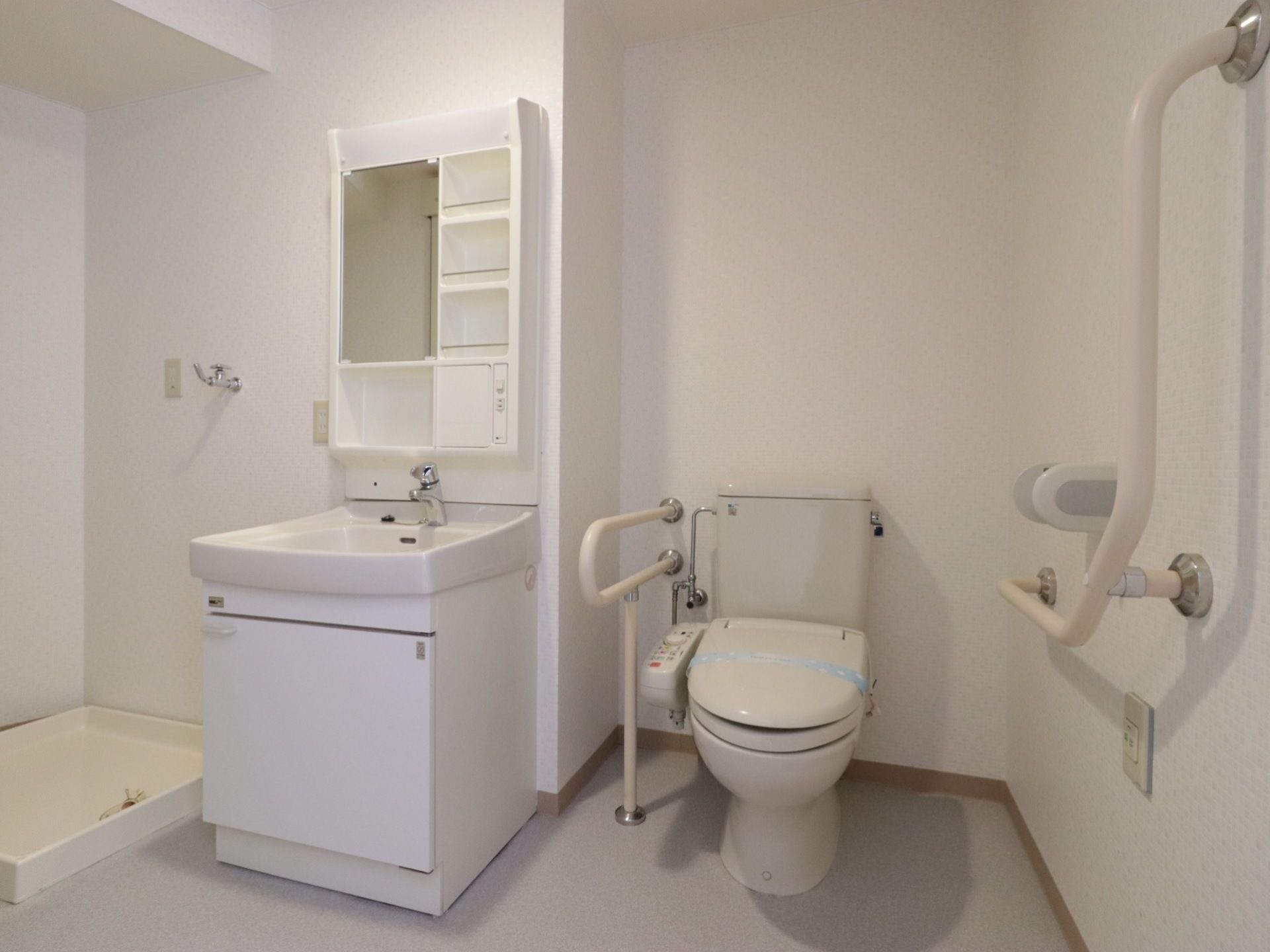 白で統一された清潔感のあるユーティリティースペースがある。トイレと洗面スペース、洗濯機置き場が一体化されている。
