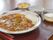 野菜がたっぷり入ったカレーと、サラダやデザートが並べられたトレー