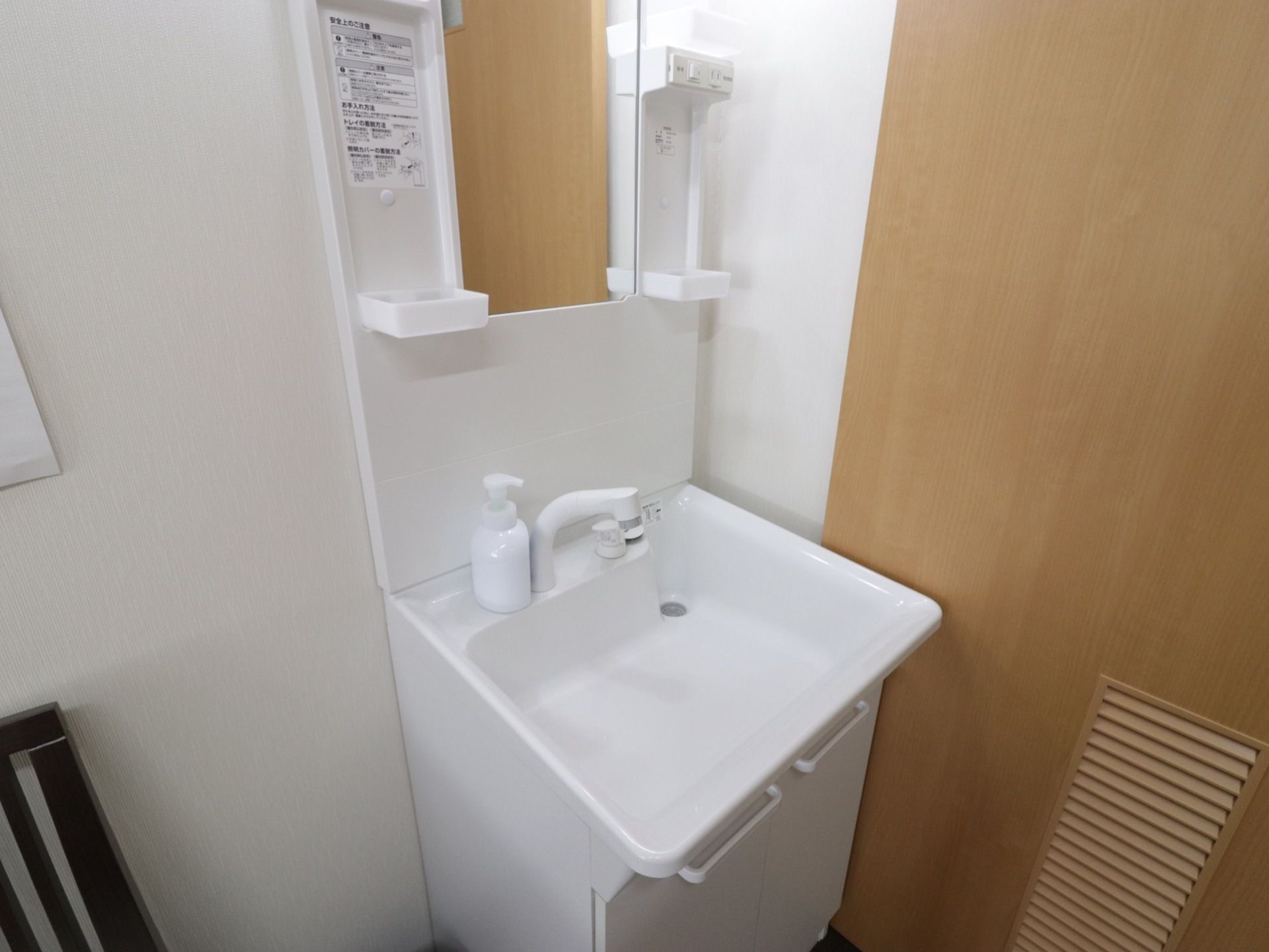 明るく収納が充実しているシンプルな洗面台が置かれている。シャワー付き蛇口なので、洗顔や洗髪をすることができる。