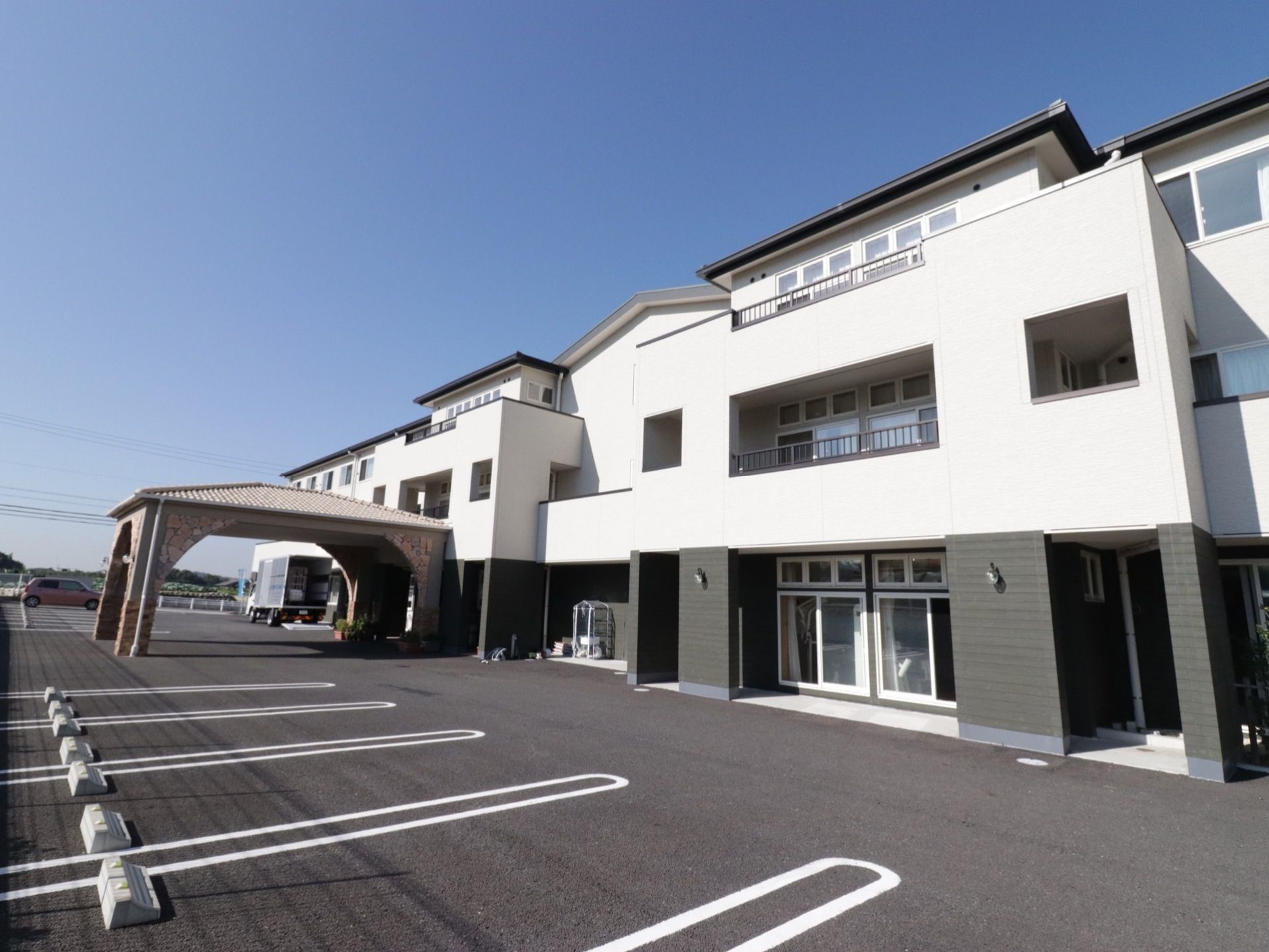 モノトーンの外壁がシックでおしゃれな施設の外観。広々な駐車場なので、車で来ても安心して停めることができる。