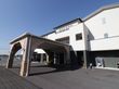 白い外壁は高級感のある作りになっている。広い駐車場から玄関までは屋根付きの通路で雨や雪でも安心して移動ができる。