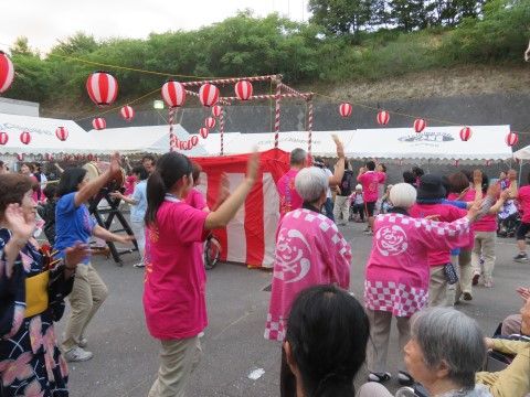 はっぴや浴衣を着て盆踊りをしている様子。