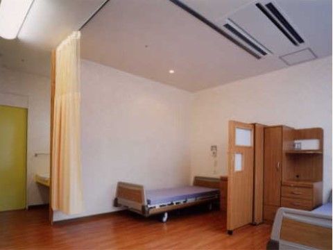 室内は天井が高く、エアコンが設置されている。床はフローリングになっており、ベッドやタンス、ロッカーが置かれている。