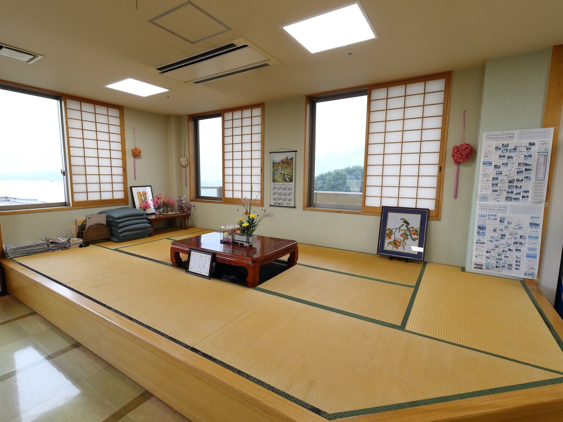 畳が敷かれた和室にはたくさんの花や額、カレンダーが飾られている。障子がついた窓からは外の景色がよく見える。