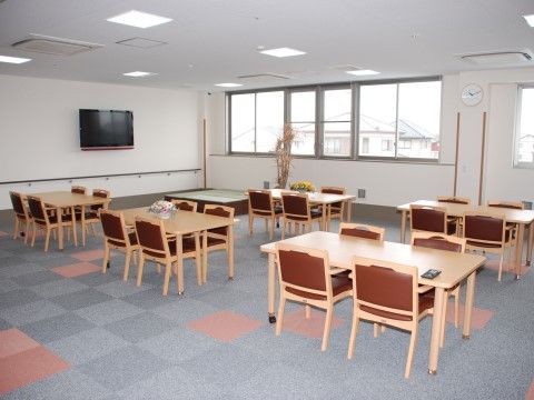 ４人掛けのテーブルや椅子が複数置かれている。天井には等間隔で四角い照明が複数設置されており、明るい。