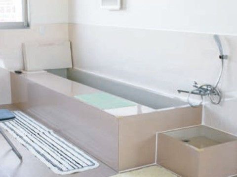 壁沿いに、白い横長の足湯用のバスタブが設置されている。脚マット隣には、パイプ椅子が１脚置かれている。
