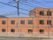 ３階建ての日当たりの良い大きなグループホームである。ブラウンを基調とした外壁で、建物前にはエアコンの室外機が複数置かれている。