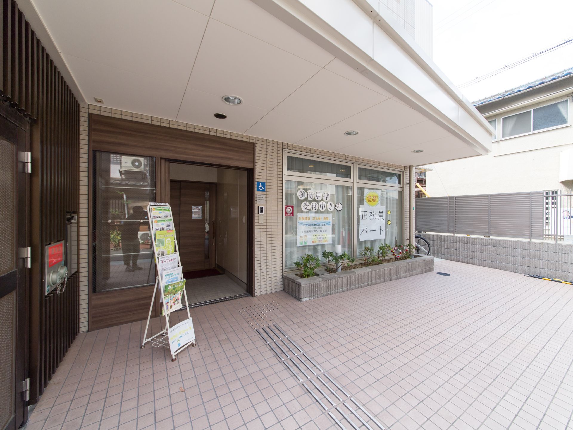 正面入口は広いスペースが設けられており、車椅子での移動も支障がない。また各種チラシが置かれたラックが設置されている。