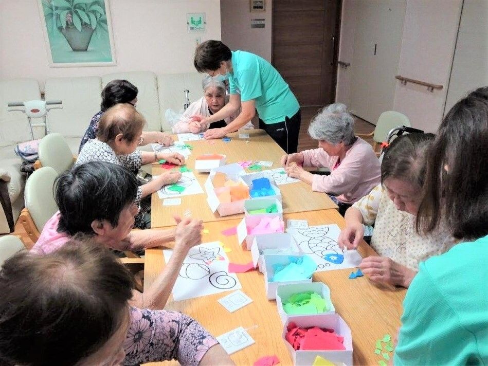 リビングのテーブルを囲んで、貼り絵に取り組む入居者様たち