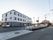 道路沿いに敷地が広がっており、３階建ての施設が建っている。周囲にフェンスが廻らされており、施設名称の書かれた横断幕が取り付けてある。